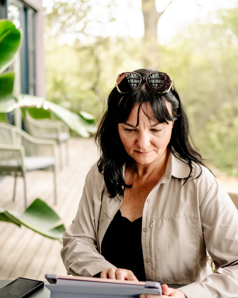 Jana arbeitet am Tablet an einem Reisekonzept mit Unterkünften und Routen